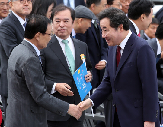 이낙연 국무총리(오른쪽)가 9일 서울 종로구 광화문 광장 세종대왕 동상 앞에서 열린 제527돌 한글날 경축식에서 더불어민주당 이해찬 대표와 악수하고 있다. 가운데는 자유한국당 김병준 비상대책위원장.  연합뉴스